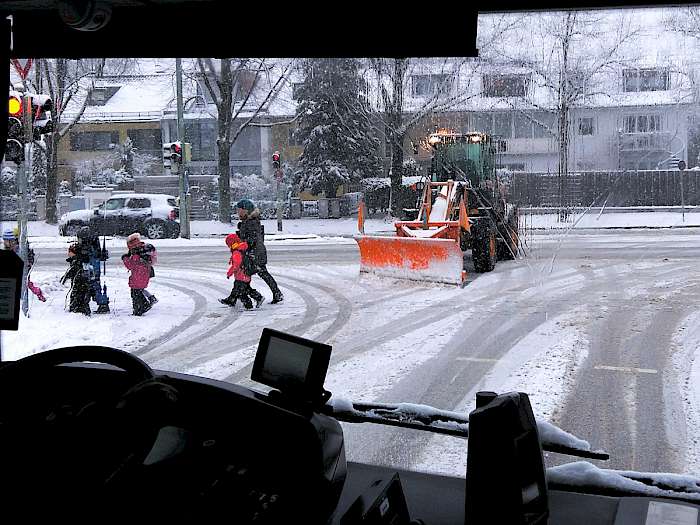 Fahrzeug mit Schneeschild räumt verschneite Straße