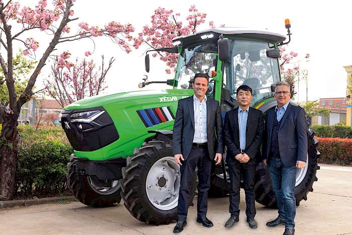 Christian Mayer (Vorstand ILaFa Radolfzell), Yongjun Chen (Geschäftsführer XEEVO) und Arnold Kemkemer vor einem Xeevo Traktor