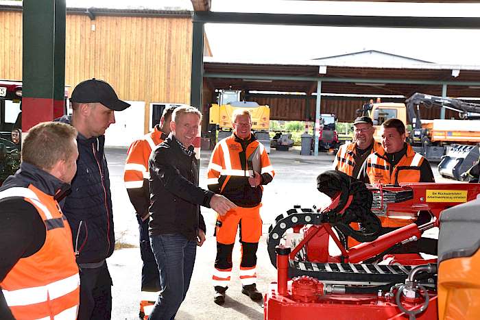 Bauhofleiter erklärt seinem Team etwas